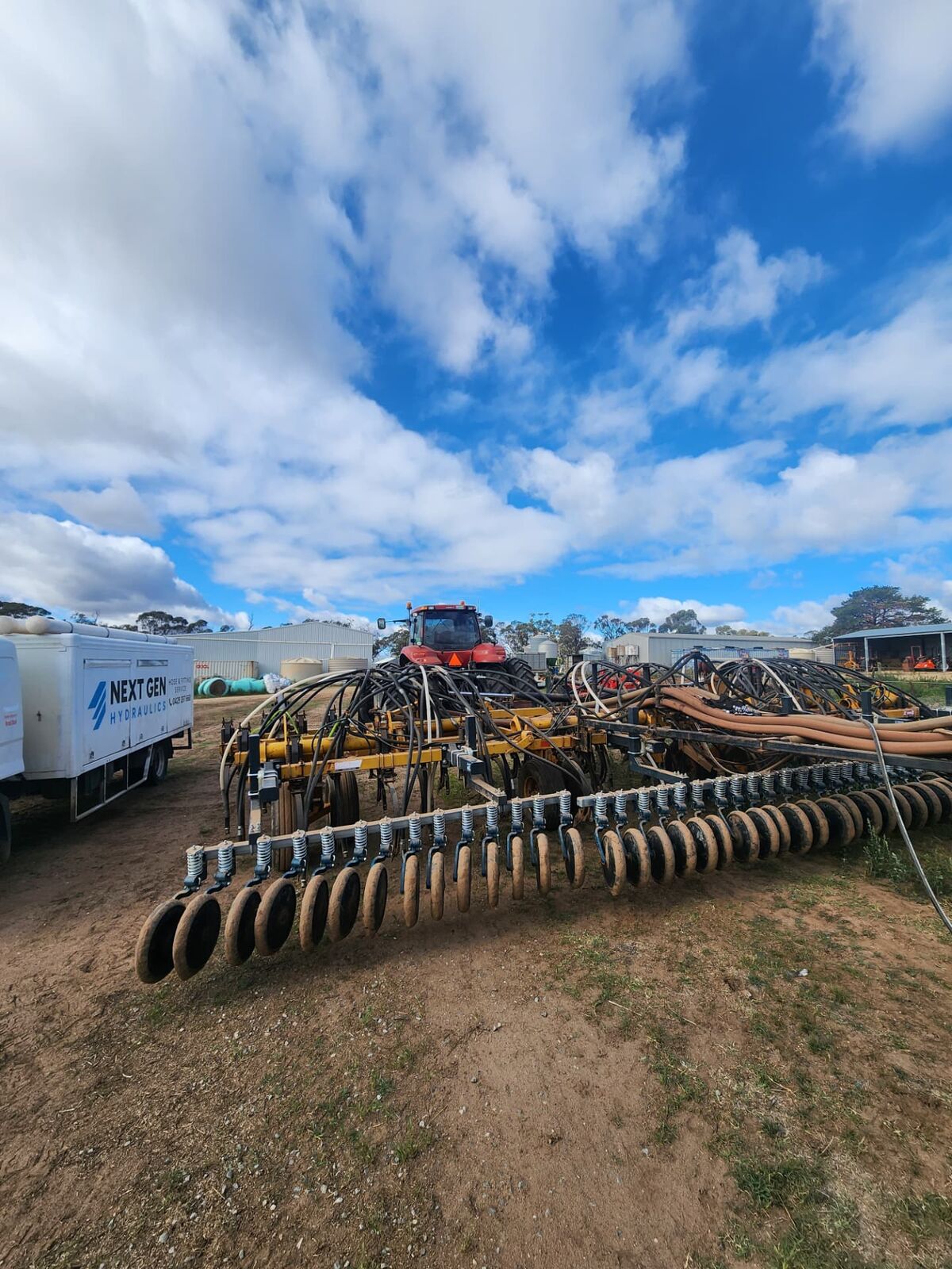 Tractor and seeder in a paddock outside Adelaide with a hydraulic hose being replaced on site